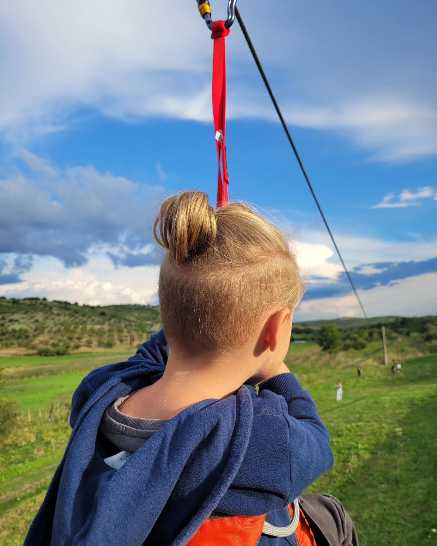 Kind auf der Seilrutsche über dem Obstgarten
